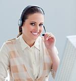 Charming businesswoman working at a computer with headset on
