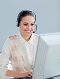 Pretty businesswoman working at a computer with headset on