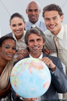 Cheerful Multi-ethnic business team showing a terrestrial globe