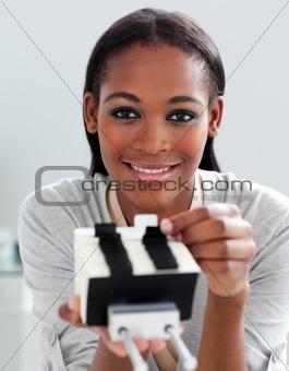 Charming ethnic businesswoman holding a business card holder 