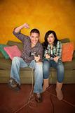 Attractive Hispanic Couple Playing a Video Game with Handheld Controllers