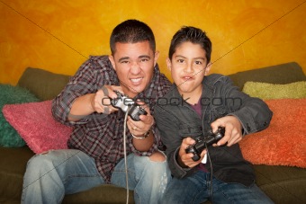 Attractive Hispanic Man and Boy Playing a Video Game with Handheld Controllers