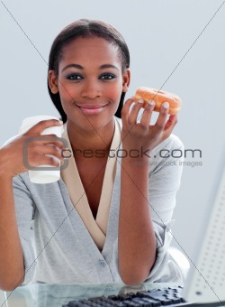Portrait of an ethnic businesswoman drinking coffee and eating d