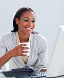 Confident businesswoman drinking a coffee at her desk