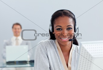 Smiling businesswoman using headset at her desk