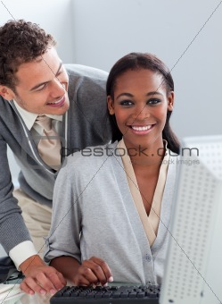 Young businessman helping his colleague at a computer