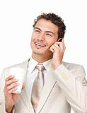 Young businessman on phone while drinking a coffee 