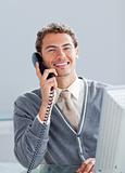 Smiling businessman on phone at his desk