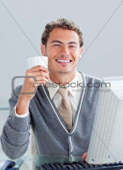Positive businessman working at a computer in the office