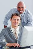 Smiling business partners working at a computer