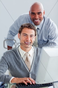 Smiling business partners working at a computer