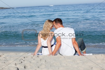 Lovers sitting on the sand 