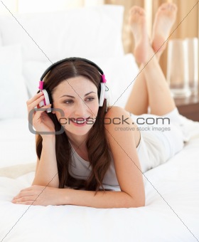 Attractive woman listening music lying on bed