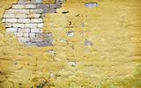 Brick wall with broken plaster
