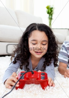 Cute girl playing video games lying on the floor 