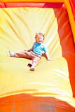 happy little boy enjoying a ride down the slide in amusement park
