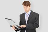 Business man with laptop on grey background
