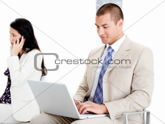 Young businessman using a laptop in a waiting room