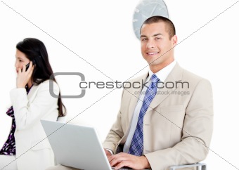 Handsome businessman using a laptop in a waiting room
