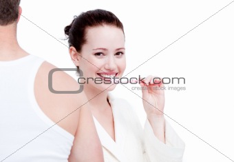 Portrait of an attractive woman brushing her teeth against a white background
