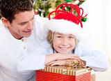 Attractive father opeing present with his son at christmas time