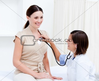 Nice female doctor examining the  patient with her stethoscope