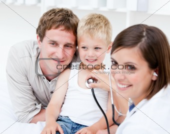 Portrait of beautiful female doctor examining a little boy with 