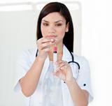 Portrait of a beautiful female doctor preparing a syringe 