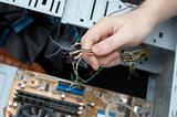 Man hand assembles computer cable into system unit