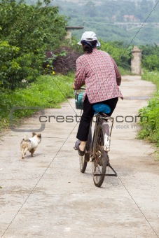 Woman on Bicycle with Dog