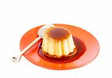 Cream caramel on red plate with spoon
