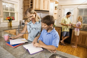 Family in kitchen doing homework and chatting.
