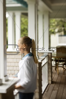 Girl standing on porch.