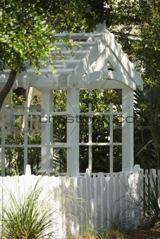 Garden arbor with white picket fence.