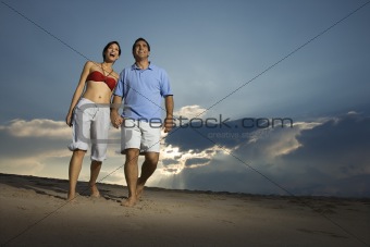 Couple walking on beach.