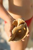 Woman holding conch shell.