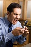 Businessman screaming at cell phone.