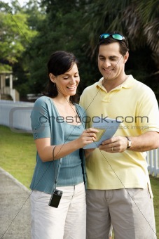 Couple holding map and smiling. 