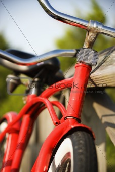 Red bike leaning against railing.