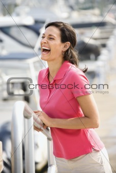 Woman holding railing and laughing.