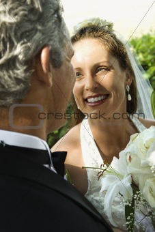 Looking over groom's shoulder at bride.