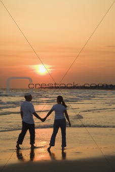 Couple on beach at sunsest.