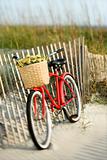 Bike leaning against fence at beach.