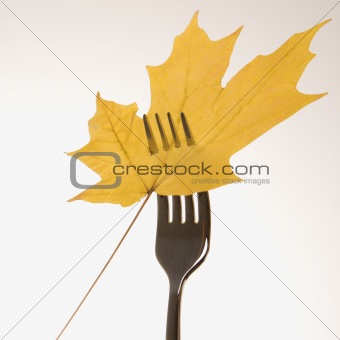 Maple leaf pierced by fork.
