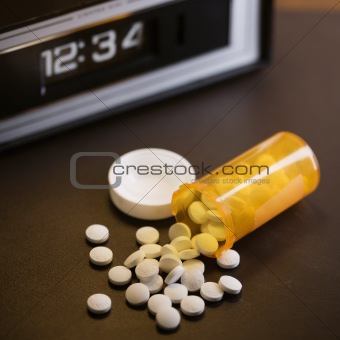 Pills spilling out of medicine bottle.