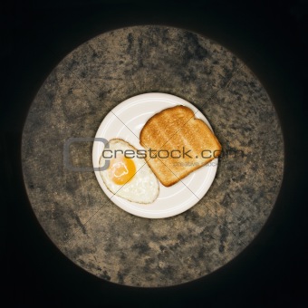 Fried egg and toast on plate.