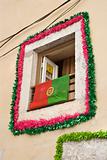 Window decorated with garland and flag in Lisbon, Portugal.
