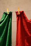 Red and green fabric hanging on clothesline in Lisbon, Portugal.