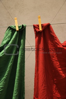 Red and green fabric hanging on clothesline in Lisbon, Portugal.