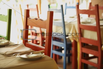 Different colored chairs at tables in Lisbon, Portugal.